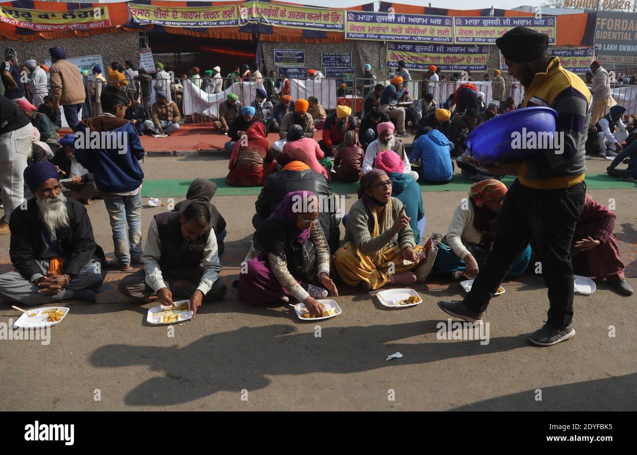 Nuova Delhi, India. 25 Dic 2020. Durante la manifestazione si vedono i contadini che pranzano in strada.migliaia di contadini del Punjab, dell'Haryana e di altri stati si sono riuniti per il trentesimo giorno per protestare contro la nuova legge agricola del centro, chiedendo di rollback di questi nuovi conti. Credit: SOPA Images Limited/Alamy Live News Foto Stock