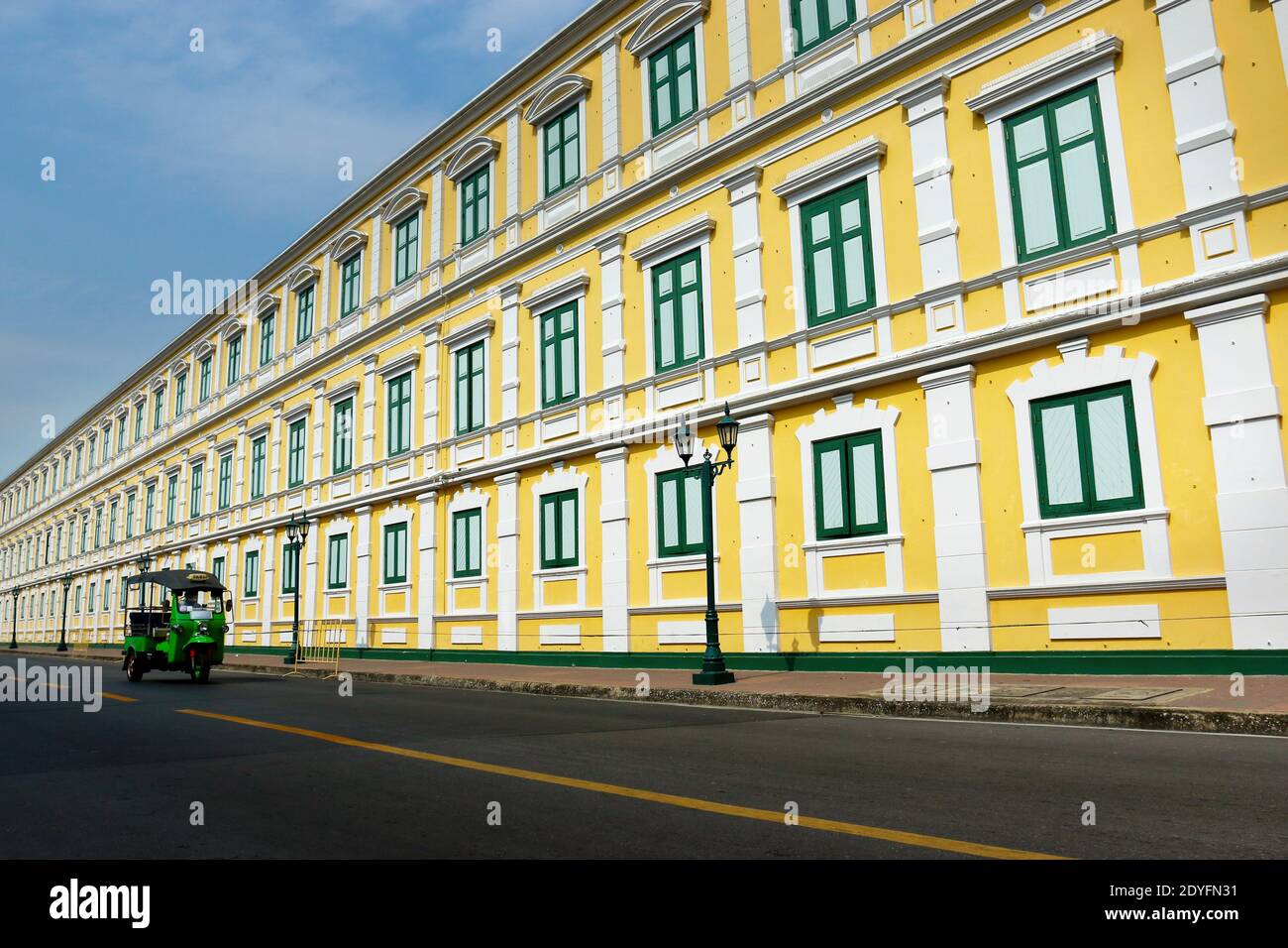 Un tuk tuk nella strada di bangkok con un vista architettonica con finestra verde su un edificio asiatico Foto Stock