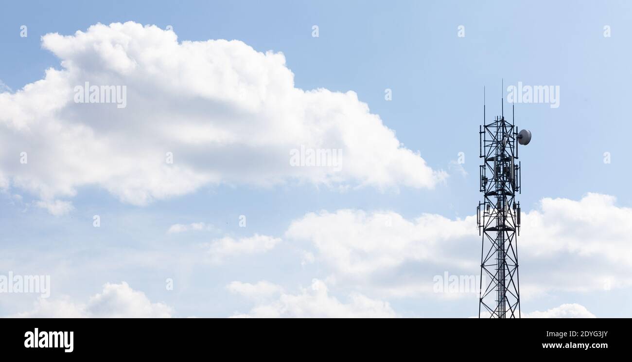Torre a cella singola, stazione base cellulare, antenna, trasmettitore su sfondo blu nuvoloso, spazio copia Telecomunicazioni, rete di telefonia cellulare Foto Stock