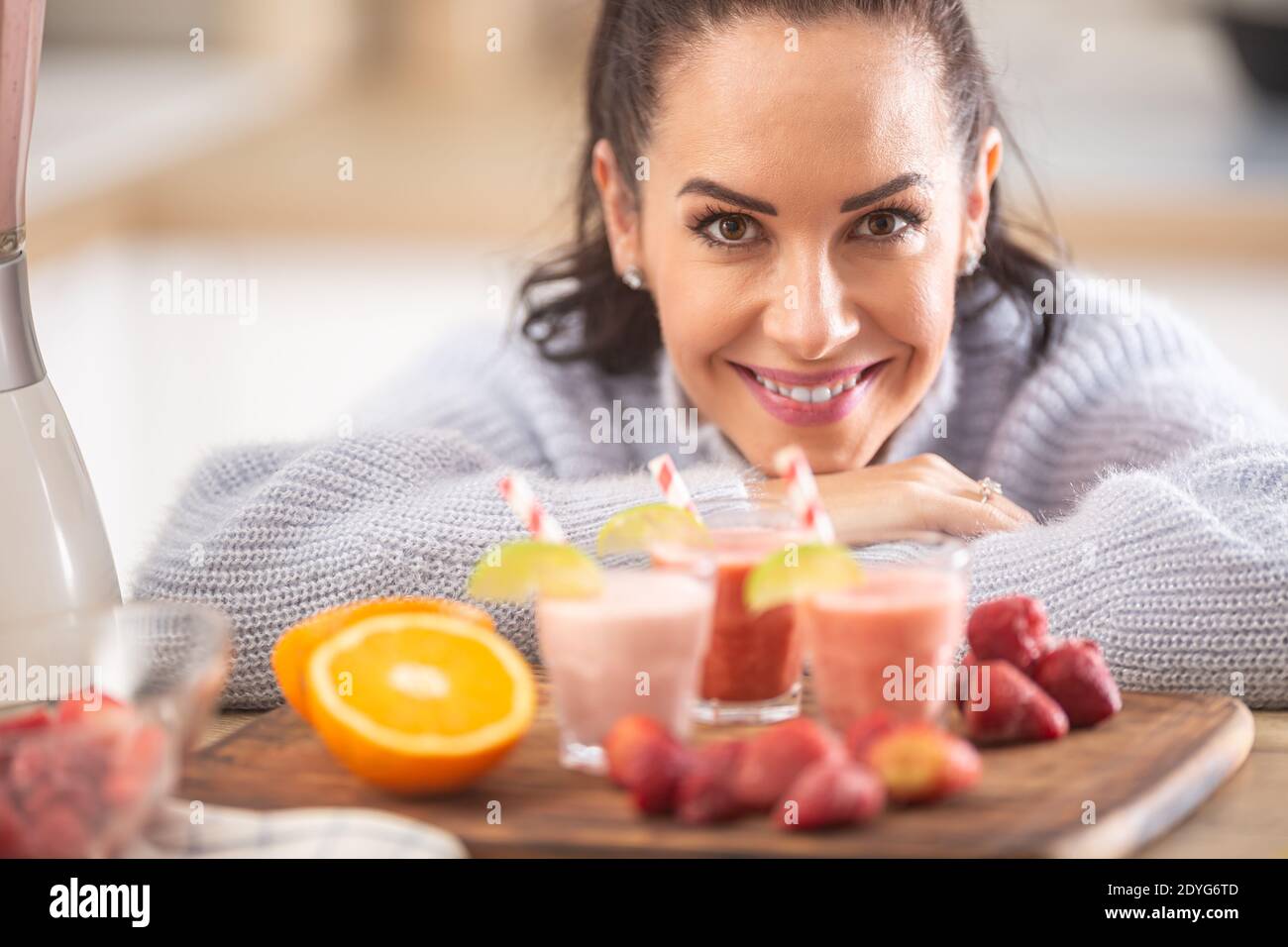 Buona donna che gode la sua casa ha fatto frullati di frutta in cucina. Foto Stock