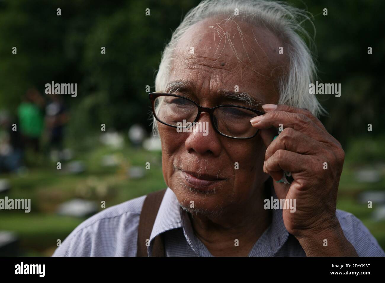 Giacarta, Indonesia. 25 Dic 2020. Harry dalle, di 78 anni, che era un Moslim e si è convertito al cristianesimo, è in pellegrinaggio alla tomba del fratello minore morto di Covid-19 nella tomba speciale per le vittime di Covid-19 al cimitero pubblico di Pondok Ranggon, Giacarta, Venerdì (25/12/2020). Il momento natalizio di quest'anno è stato utilizzato da diversi cristiani per compiere pellegrinaggi e pregare per i parenti che sono stati sepolti sotto il protocollo del Covid-19. (Foto di Kuncoro Widyo Rumpoko/Pacific Press/Sipa USA) Credit: Sipa USA/Alamy Live News Foto Stock