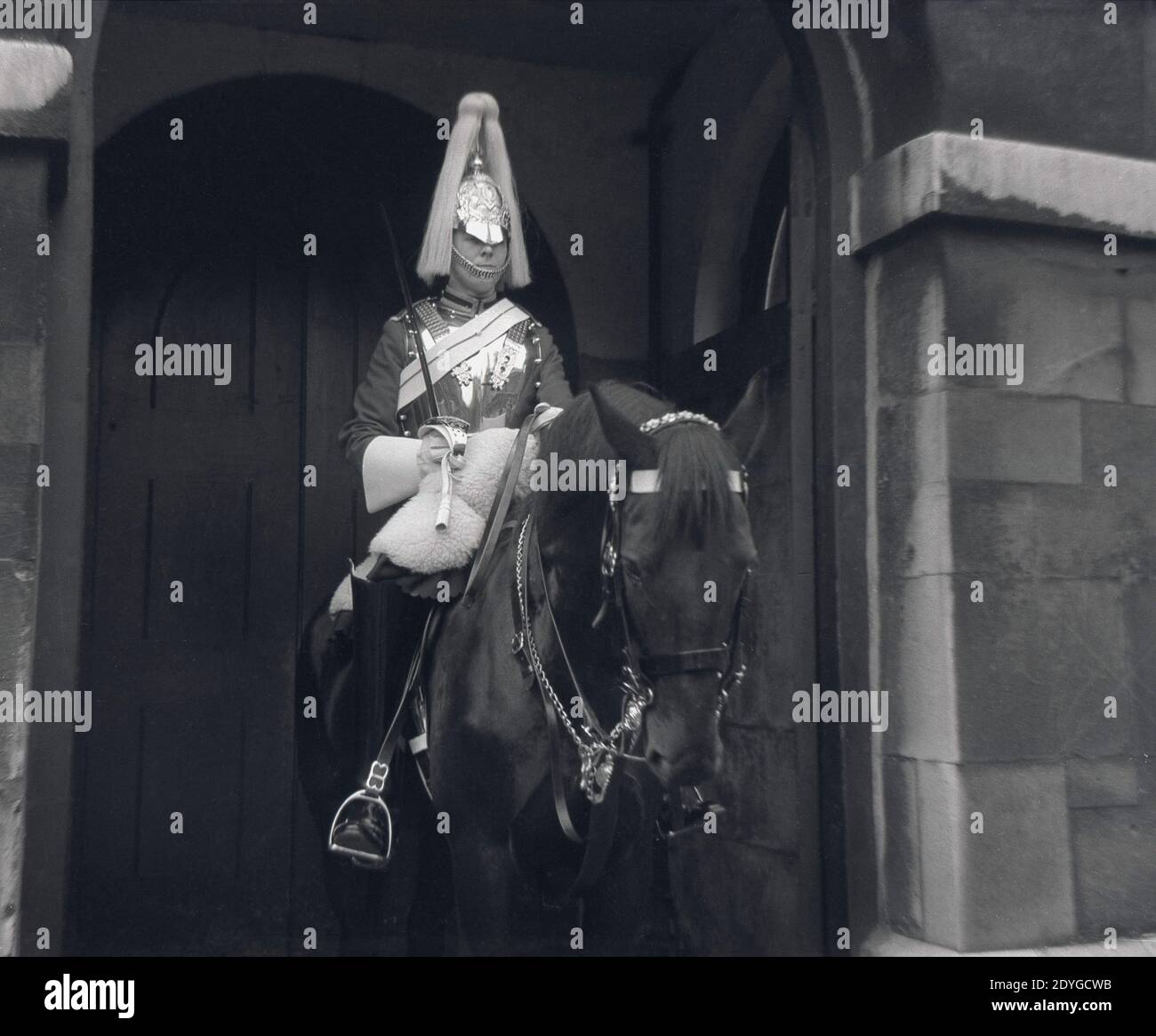 Anni '60, storico, una guardia di vita della Regina, in uniforme cerimoniale e spada, seduto sul suo cavallo in servizio di entrata all'ingresso di Horse Guards on Whitehall a Londra, Inghilterra, Regno Unito. La Guardia di vita della Regina è fornita da uomini del Reggimento montato dalla Casa Cavalleria e sono stati presenti sin dalla restaurazione della monarchia e re Carlo II nel 1660. Foto Stock