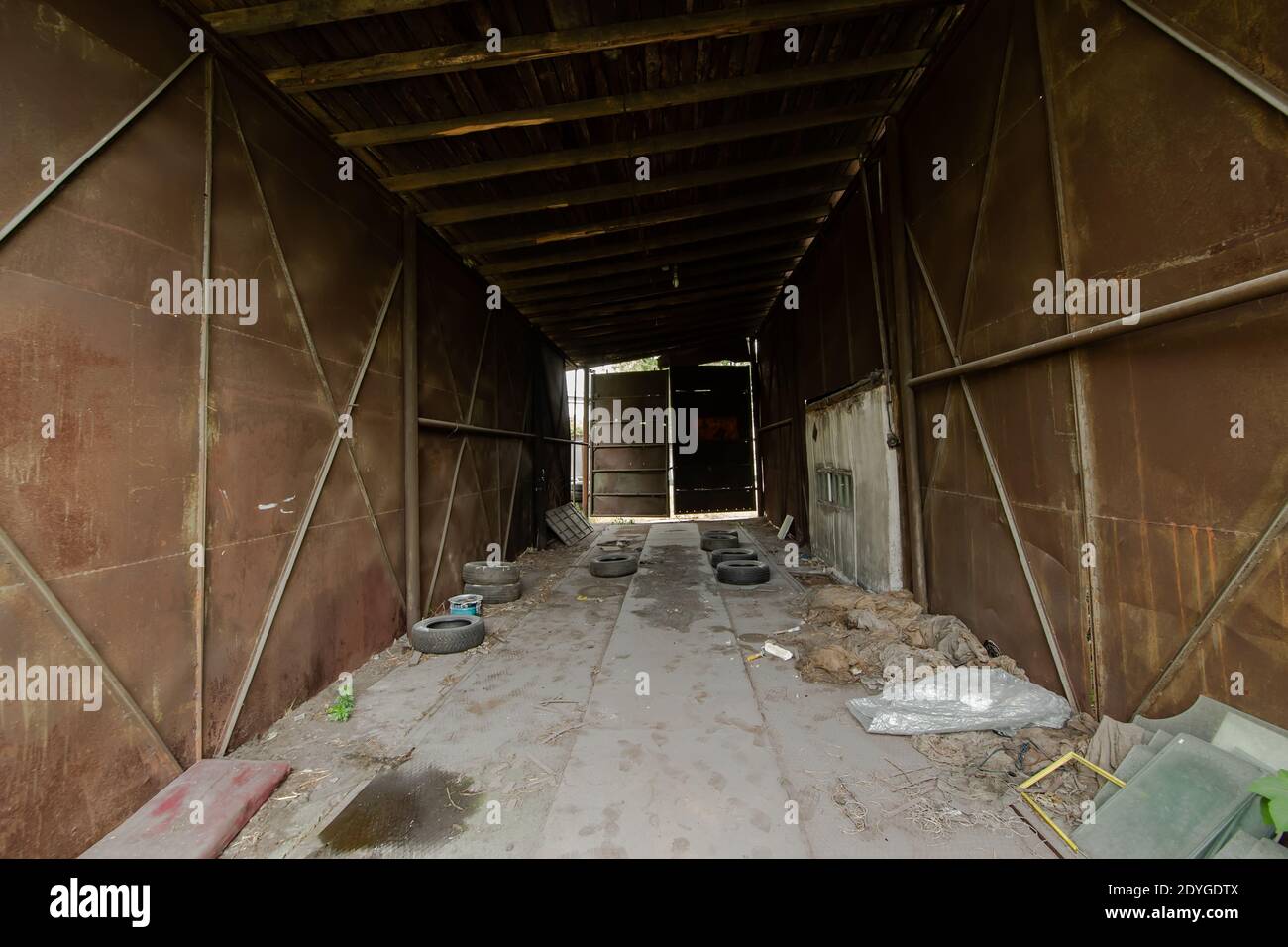 L'interno di un vecchio garage abbandonato con metallo arrugginito muri Foto Stock