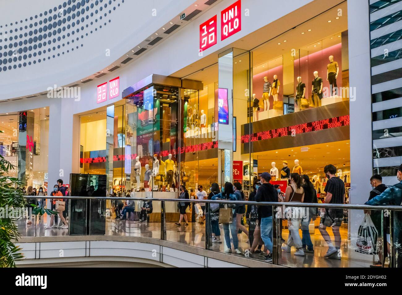 Persone che passano accanto al negozio UNI QLO nel centro commerciale Chadstone durante il giorno di Santo Stefano. Foto Stock