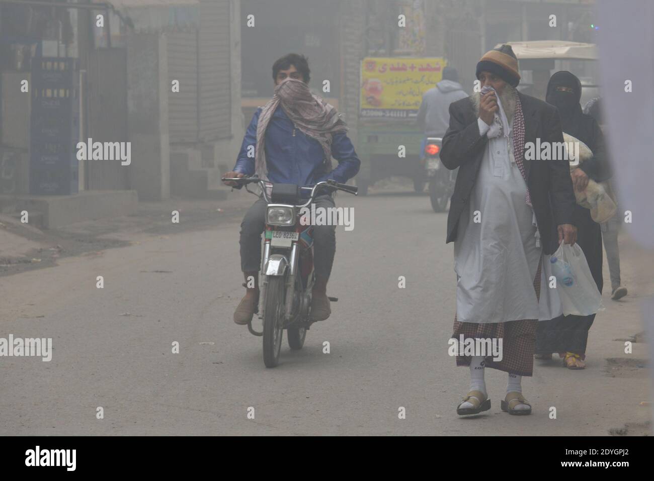 I pendolari pakistani fanno il loro senso fra la nebbia densa su un Inverno freddo a Lahore Foto Stock