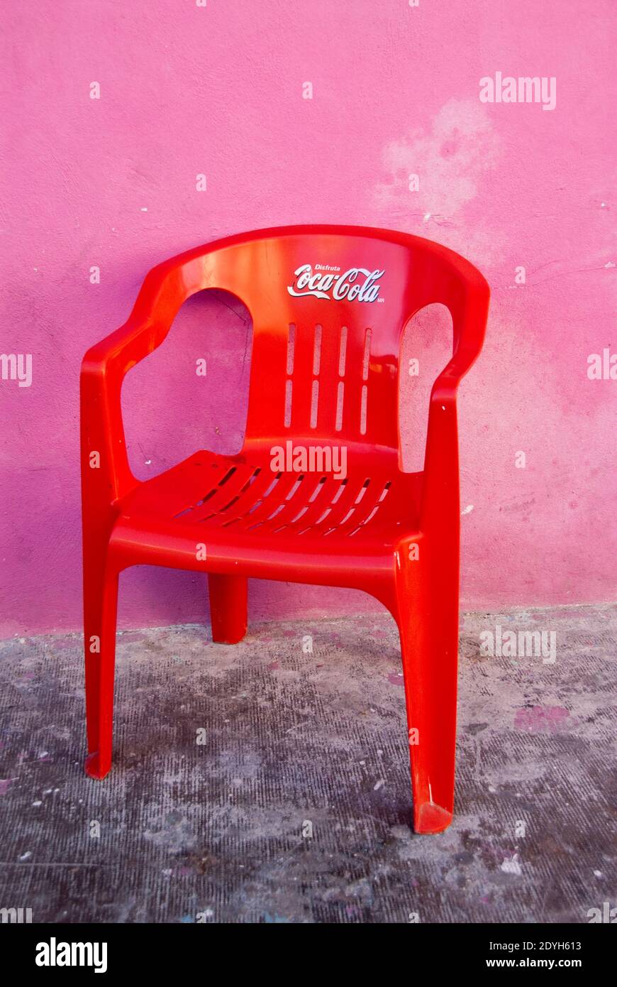Una colorata sedia in plastica Coca Cola rossa e un edificio in stucco rosa  nella città di Isla Mujeres, Messico Foto stock - Alamy