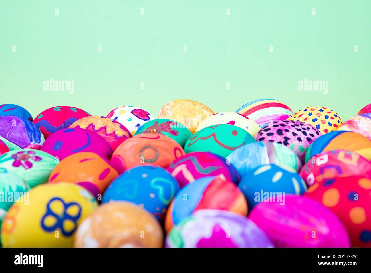 uova dipinte prima di sfondo verde, motivo di pasqua Foto Stock