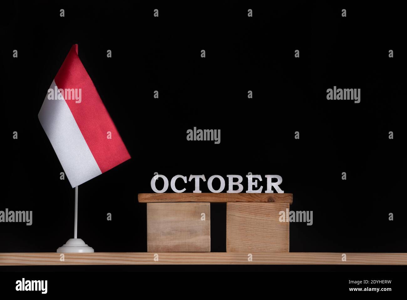 Calendario in legno di ottobre con bandiera polacca su sfondo nero. Vacanze della Polonia nel mese di ottobre Foto Stock