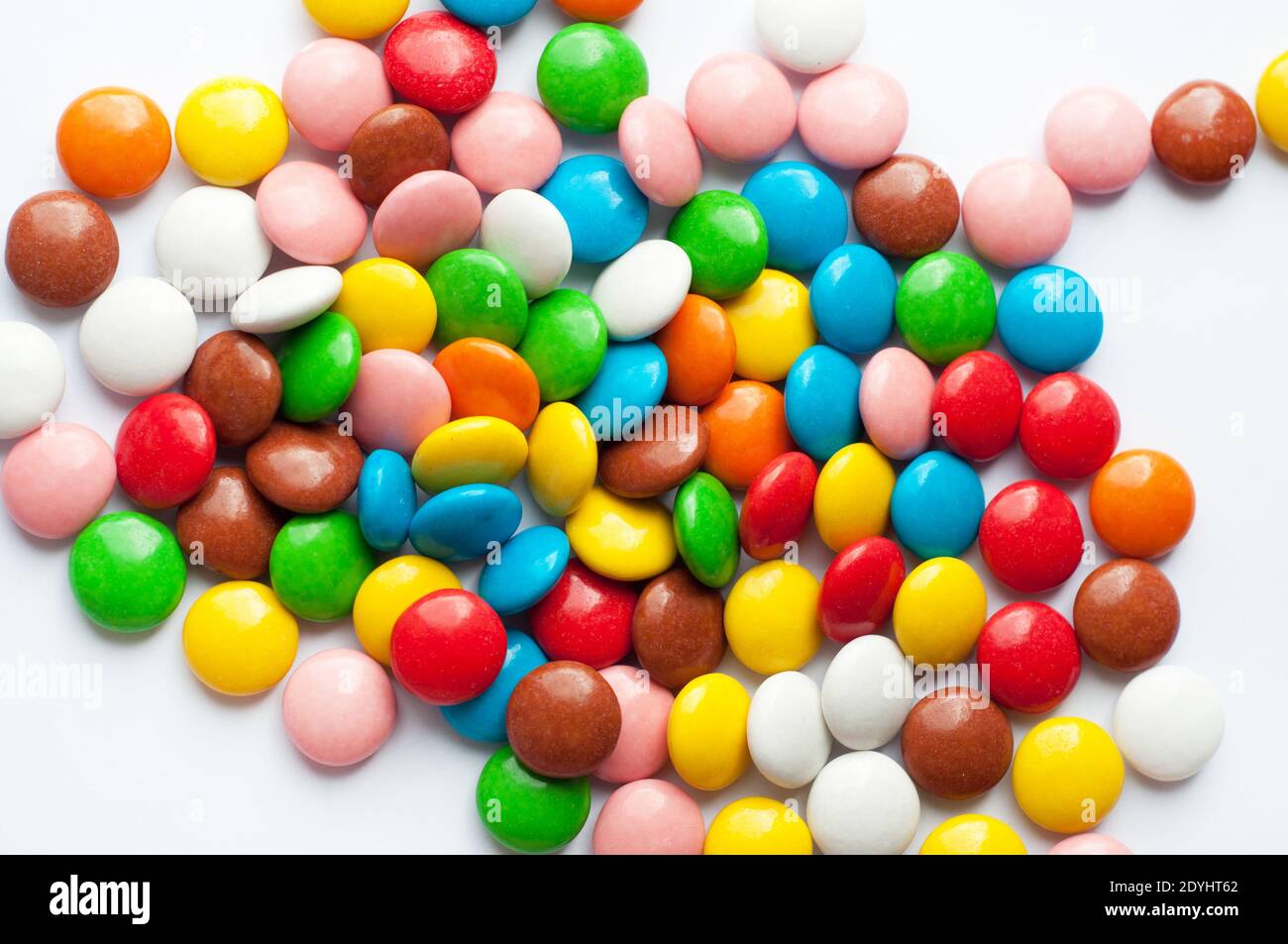 Caramelle tonde colorate su sfondo bianco. Caramelle al cioccolato  ricoperte di glassa di zucchero multicolore Foto stock - Alamy