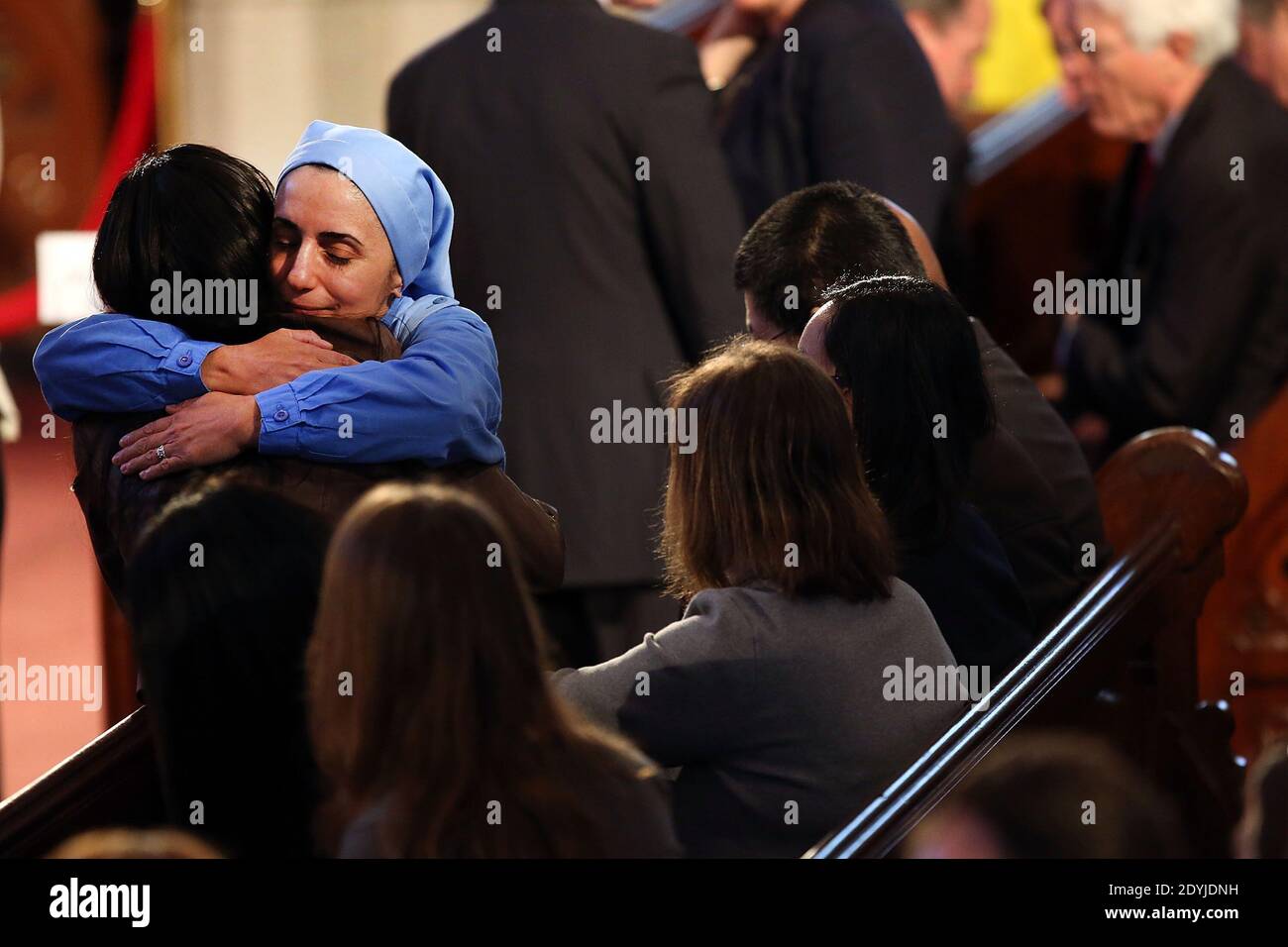 Una suora abbracca una donna in un servizio di preghiera interreligiosa per le vittime dell'attacco della maratona di Boston intitolato 'Healing Our City', e ha partecipato il presidente Barack Obama e la prima signora Michelle Obama alla Cattedrale della Santa Croce a Boston, Massachusetts il 18 aprile 2013. Le autorità che indagano sull'attacco alla Maratona di Boston hanno spostato il loro fuoco a localizzare la persona che ha messo una borsa nera giù e ha camminato via poco prima che le bombe andassero fuori. I bombardamenti gemellati durante la corsa di Boston di 116 anni, che si sono verificati vicino al traguardo della maratona, hanno provocato la morte di tre persone e più tha Foto Stock