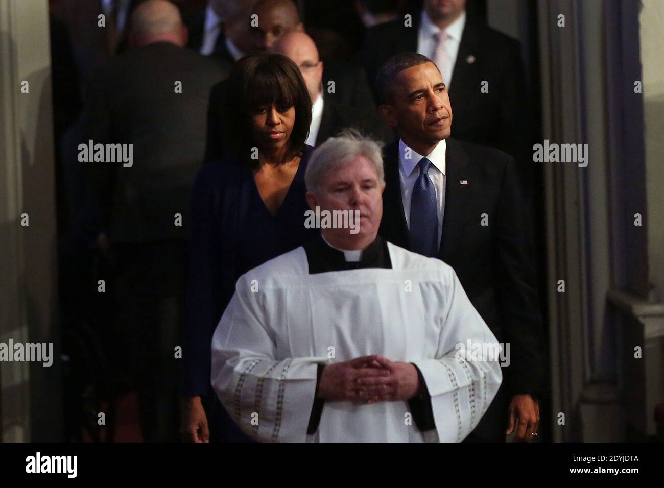 Il presidente Barack Obama (R) e la prima signora Michelle Obama entrano in un servizio di preghiera interconfessionale per le vittime dell'attacco della maratona di Boston intitolato "Healing Our City", presso la Cattedrale della Santa Croce di Boston, Massachusetts, USA il 18 aprile 2013. Le autorità che indagano sull'attacco alla Maratona di Boston hanno spostato il loro fuoco a localizzare la persona che ha messo una borsa nera giù e ha camminato via poco prima che le bombe andassero fuori. I bombardamenti gemellati durante la corsa di Boston di 116 anni, avvenuta vicino al traguardo della maratona, hanno provocato la morte di tre persone e più di 170 feriti. P. Foto Stock