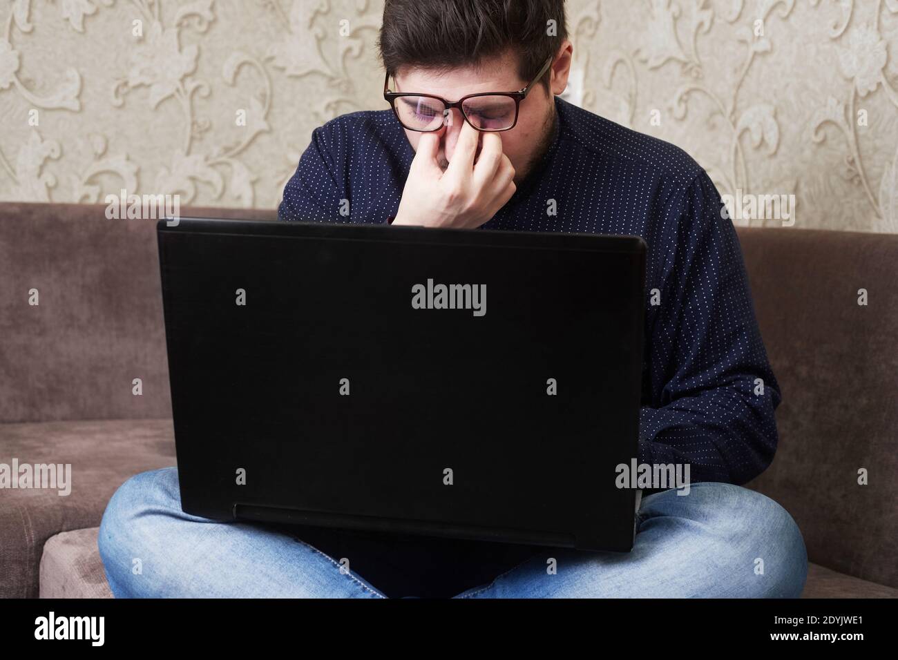 Concept, un uomo caucasico che indossa occhiali fa male gli occhi dietro una nota di faggio, copie di spazio Foto Stock Concept, un uomo caucasico che indossa occhiali fa male gli occhi dietro una nota di faggio, copie di spazio Foto Stock