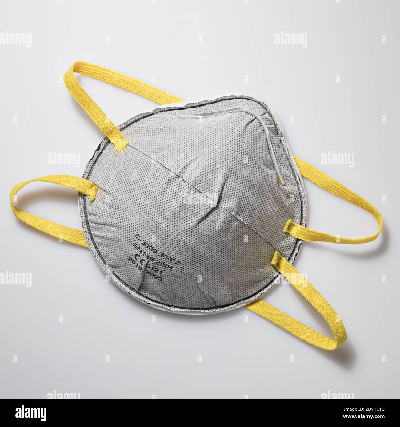 Colore e accessori dell'anno 2021. Maschera protettiva grigia con fascia elastica gialla Foto Stock