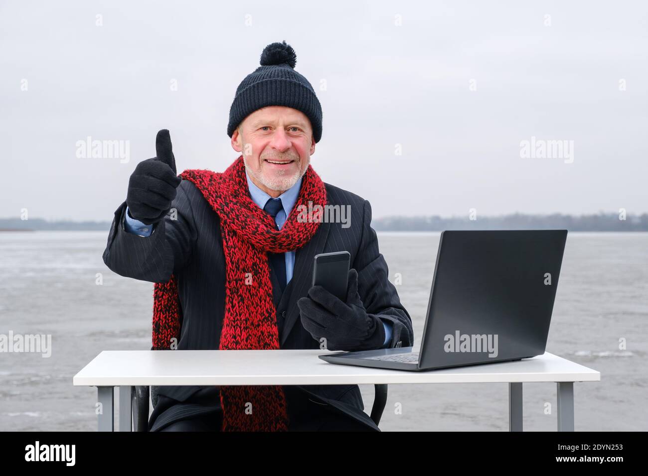 uomo d'affari anziano con la bearded grigia in tuta, sorridente mentre parla sullo smartphone Foto Stock