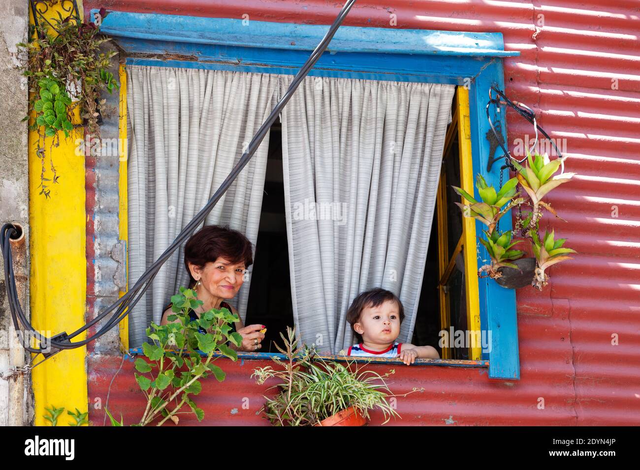 Argentina, Buenos Aires - i residenti giovani e vecchi di la Boca guardano il mondo fuori su El Caminito. Foto Stock