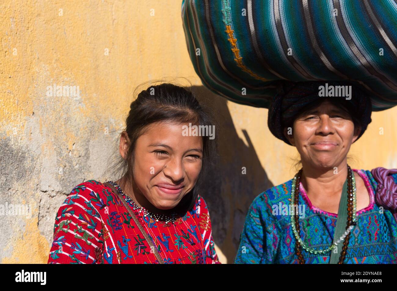 Antigua, Guatemala ragazza indigena che ride, con madre Foto Stock