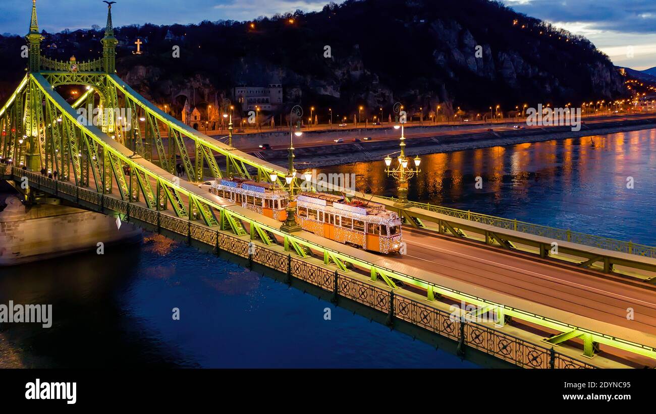 Splendida foto sul tram decorato con luci natalizie nel Ponte della libertà di Budapest, Ungheria. Questo tram funziona solo nel periodo natalizio ogni anno. Amazzoni Foto Stock