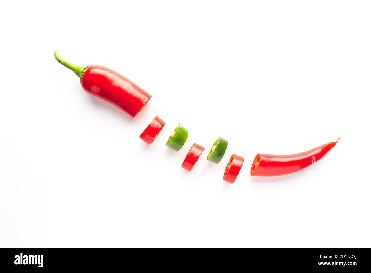 Peperoncino rosso e verde affettato ​​on su fondo bianco. Gastronomia e condimenti di cucina. Foto Stock