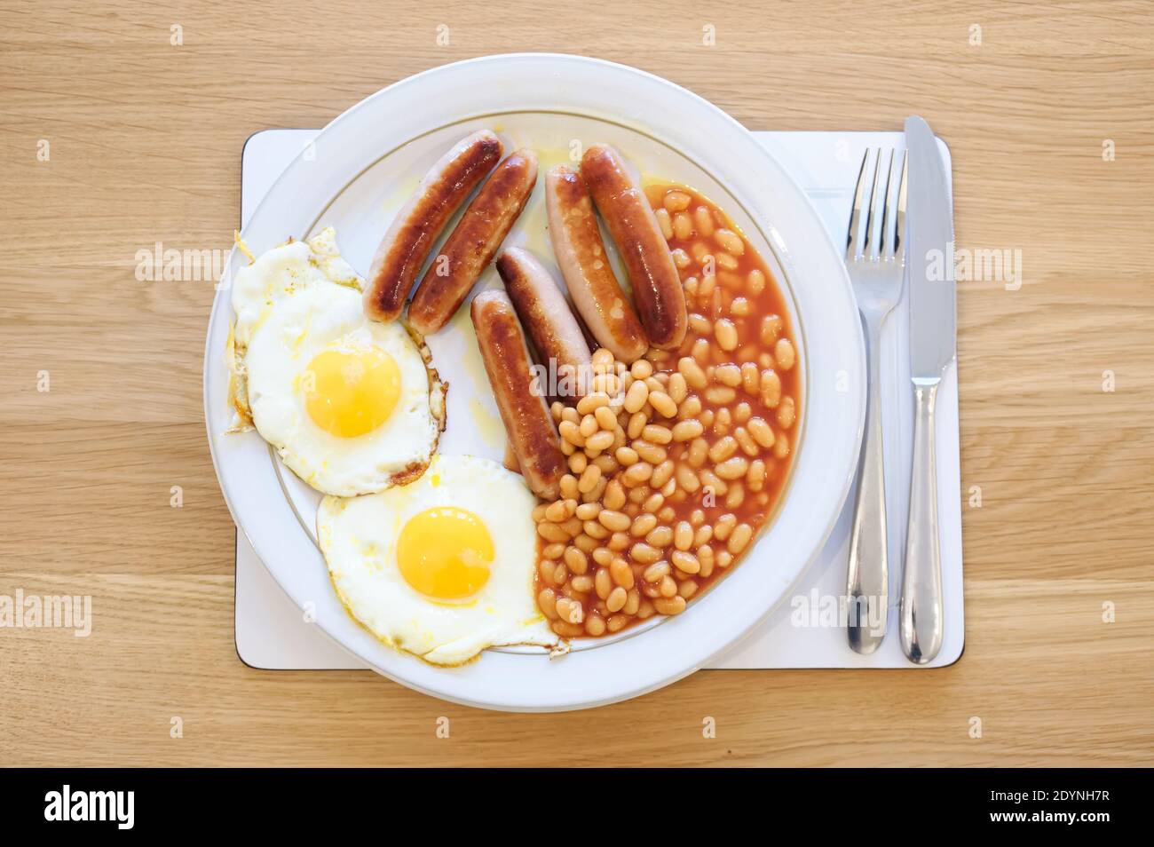 Colazione fritta con fagioli di salsiccia e uova sul piatto Foto Stock