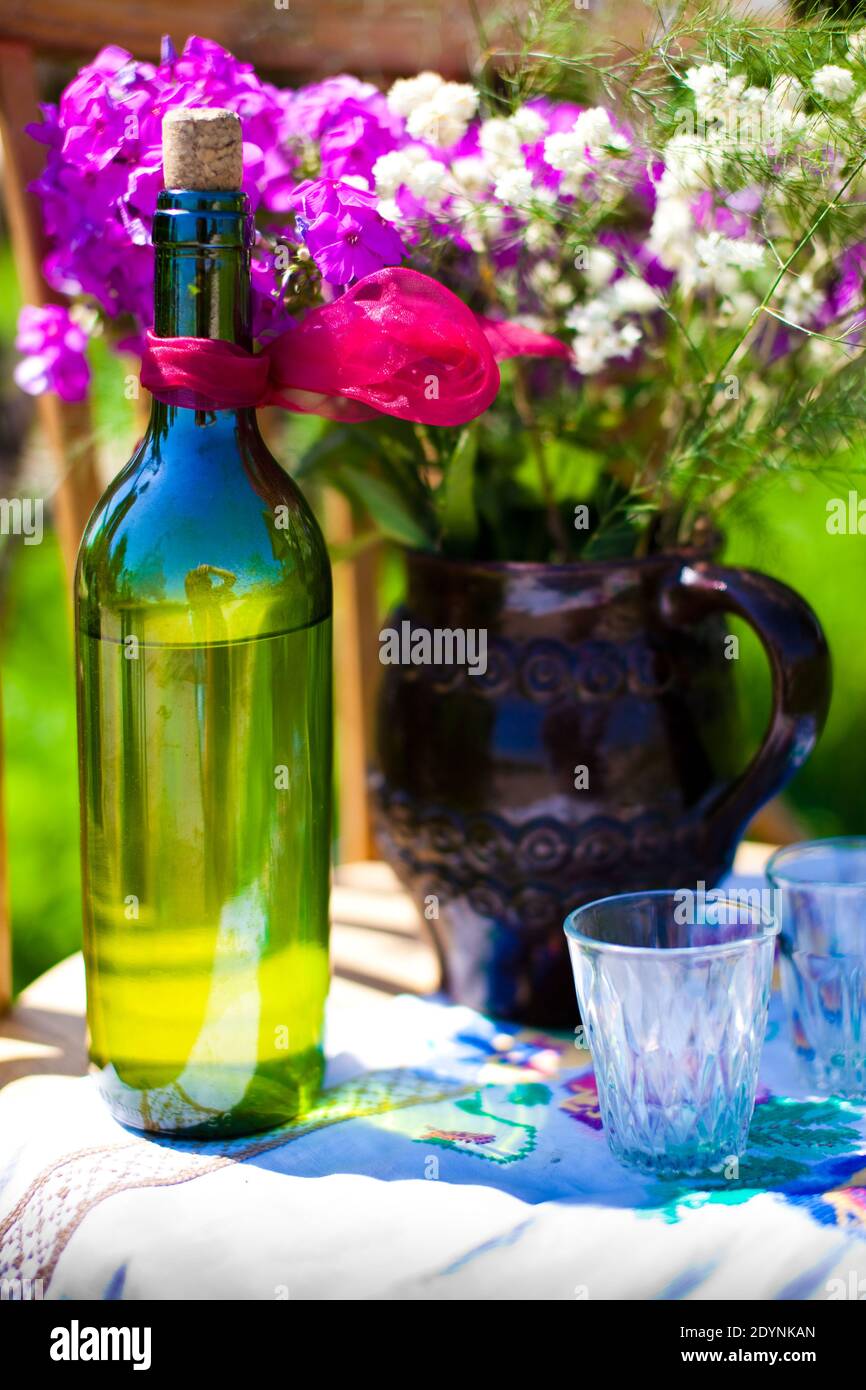 Decorazione in un matrimonio russo. Bere vodka. Vetro e bottiglia. Bouquet di fiori. Foto Stock