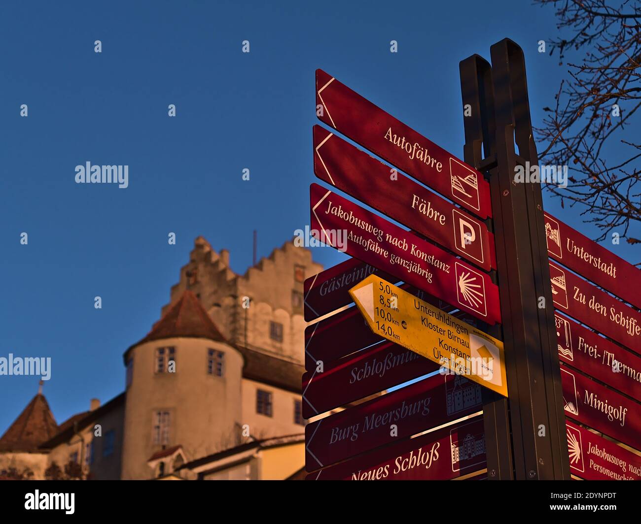 Vista in primo piano del cartello che indica le direzioni delle principali destinazioni e monumenti con il castello storico sullo sfondo. Concentratevi sui cartelli anteriori. Foto Stock