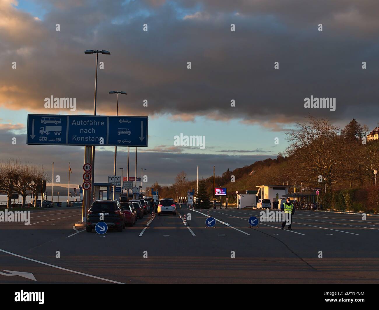 Si sono schierate vetture in attesa del traghetto per Costanza per attraversare il Lago di Costanza in luce serale nella stagione invernale. Testo: Traghetto per Costanza. Foto Stock