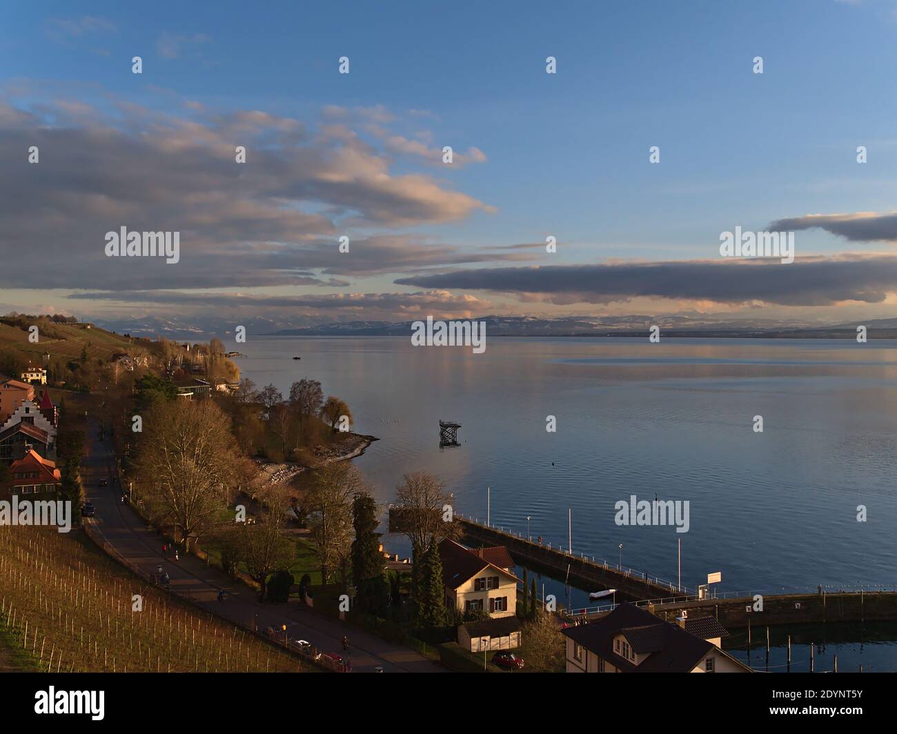 Splendida vista sulla riva del lago di Costanza vicino alla città di Meersburg, Germania con vigneti sul pendio e montagne innevate all'orizzonte. Foto Stock