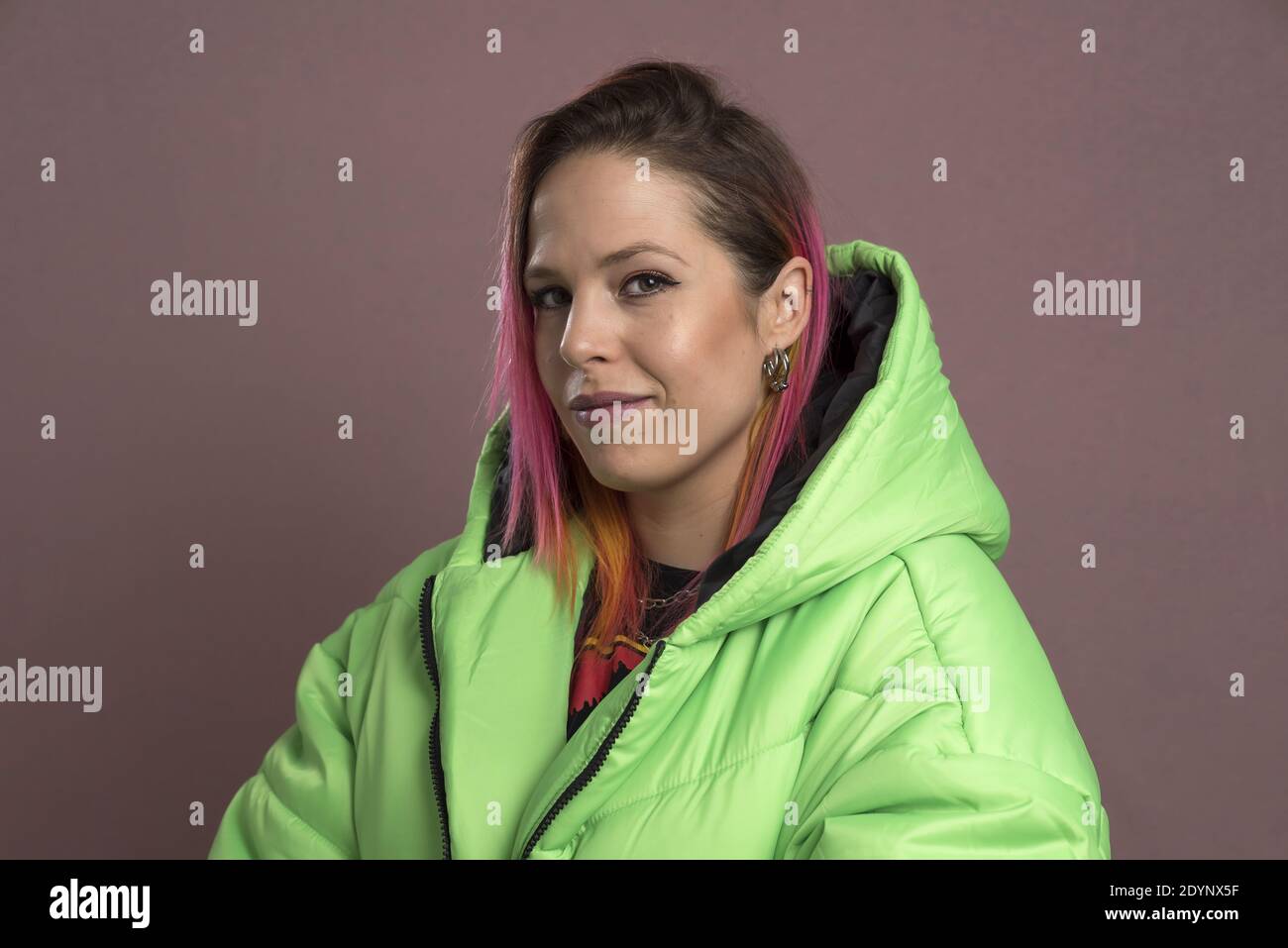 Una giovane donna con capelli rosa che indossa un soffriggitore verde giacca Foto Stock