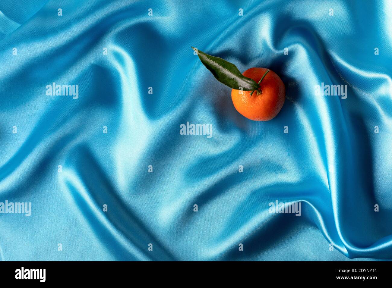tangerini singoli su raso blu Foto Stock