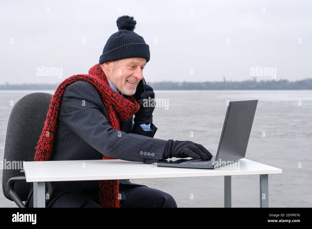 uomo d'affari anziano con la bearded grigia in tuta, sorridente mentre parla sullo smartphone Foto Stock