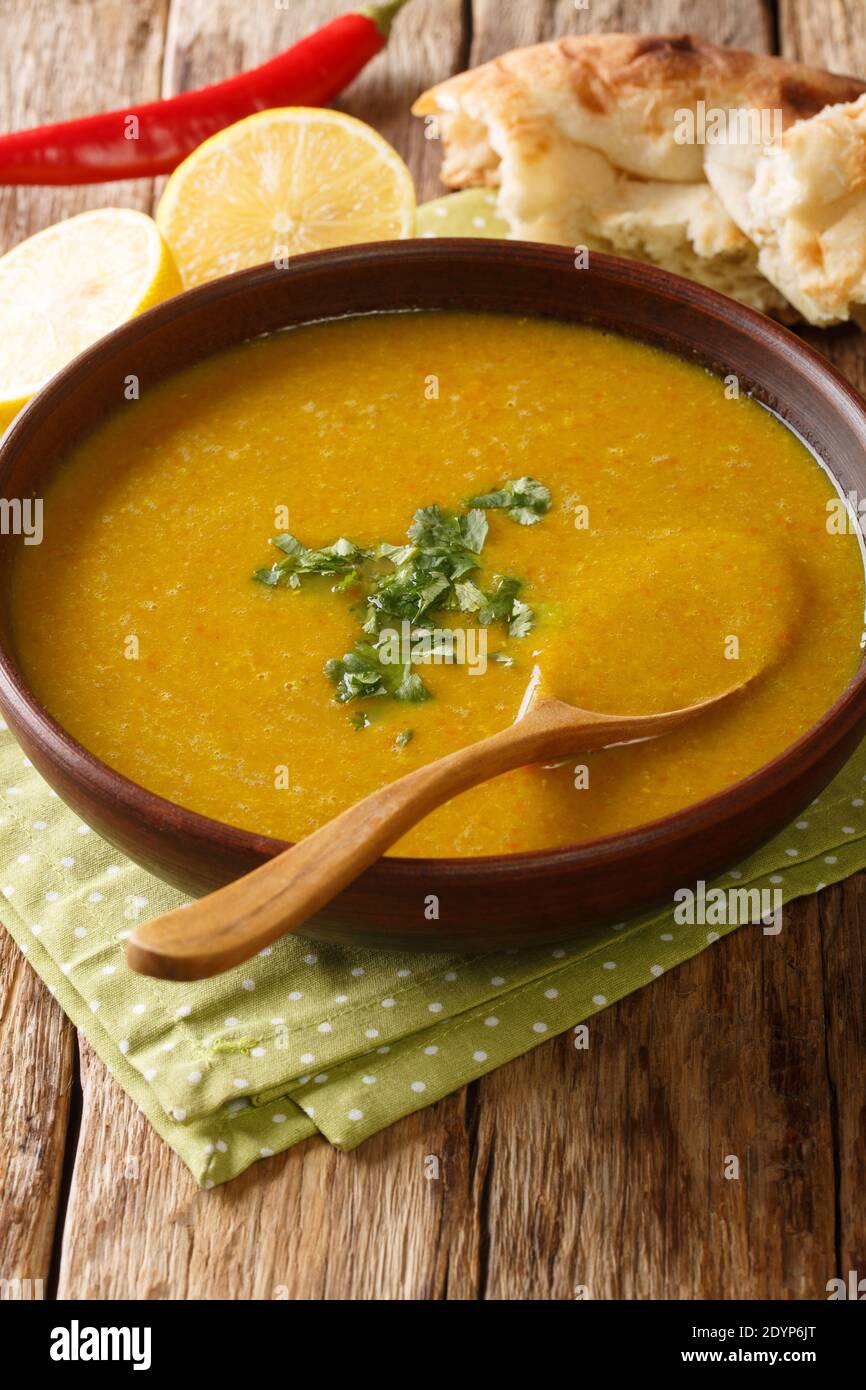 Preparazione della zuppa di lenticchie rosse di Shorbat Adas nella ciotola sul tavolo. Verticale Foto Stock