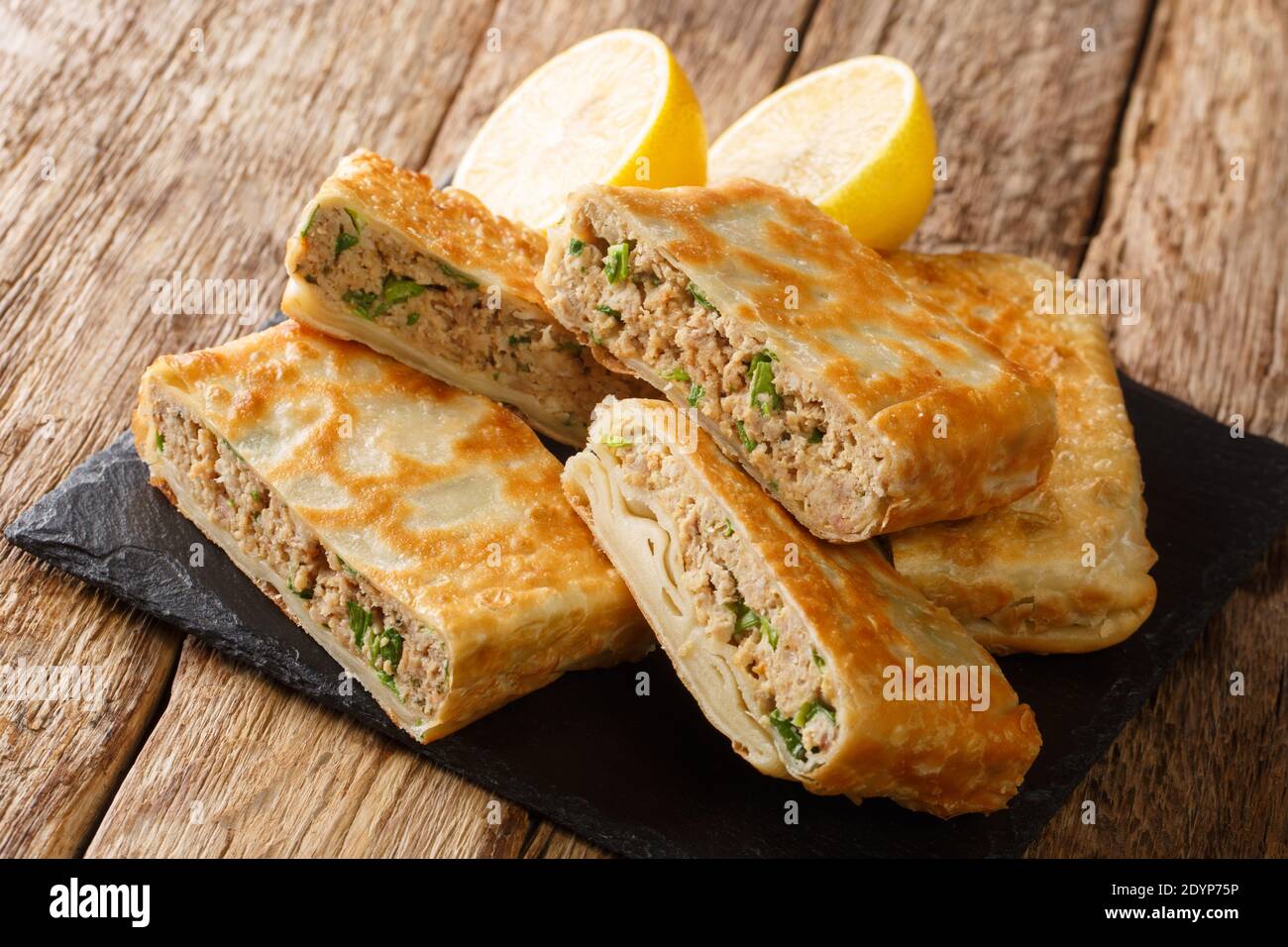Mutabbaq anche chiamato come Murtabak è un cibo di strada molto famoso del medio Oriente specialmente Arabia Saudita primo piano nel bordo sul tavolo. Orizzontale Foto Stock