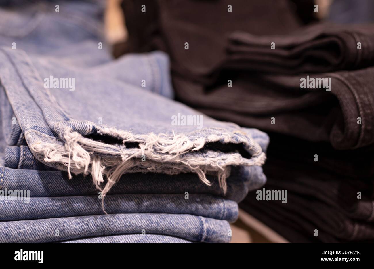 Abbigliamento donna - collezione autunno inverno. Pantaloni denim in negozio. Il concetto di consumo cosciente e riciclaggio delle cose. Foto Stock