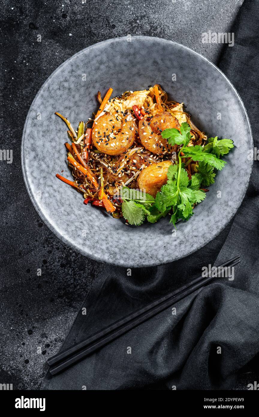 Singapore Mei Fun. Tagliatelle di riso con gamberi, gamberi, maiale al ciar siu, carota, cipolla, cavolo di nappa. Sfondo nero. Vista dall'alto Foto Stock