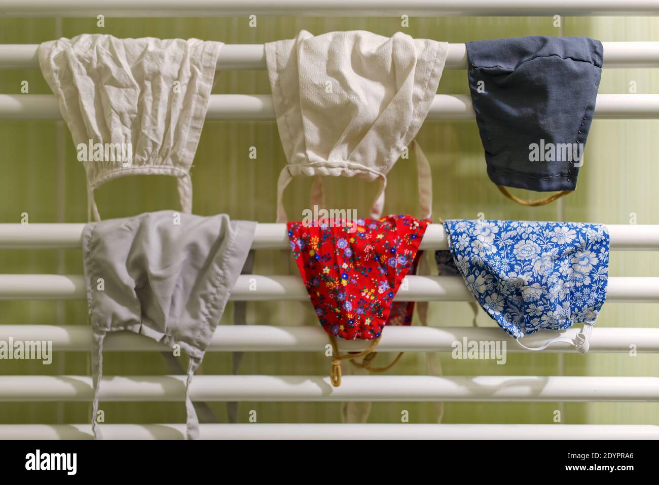 Maschere lavate che asciugano sul riscaldatore del bagno. Foto Stock