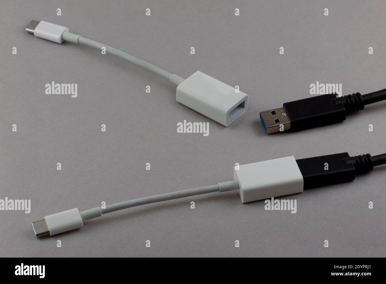 due cavi usb e adattatori usb-c a usb, un set collegato e l'altro scollegato, su sfondo grigio Foto Stock