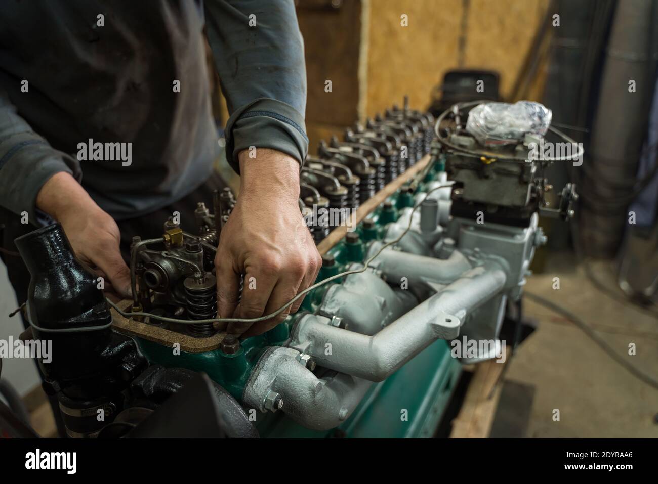 Meccanico dell'automobile che ripara un motore. Meccanico che lavora sul motore dell'automobile. Officina meccanica. Foto Stock