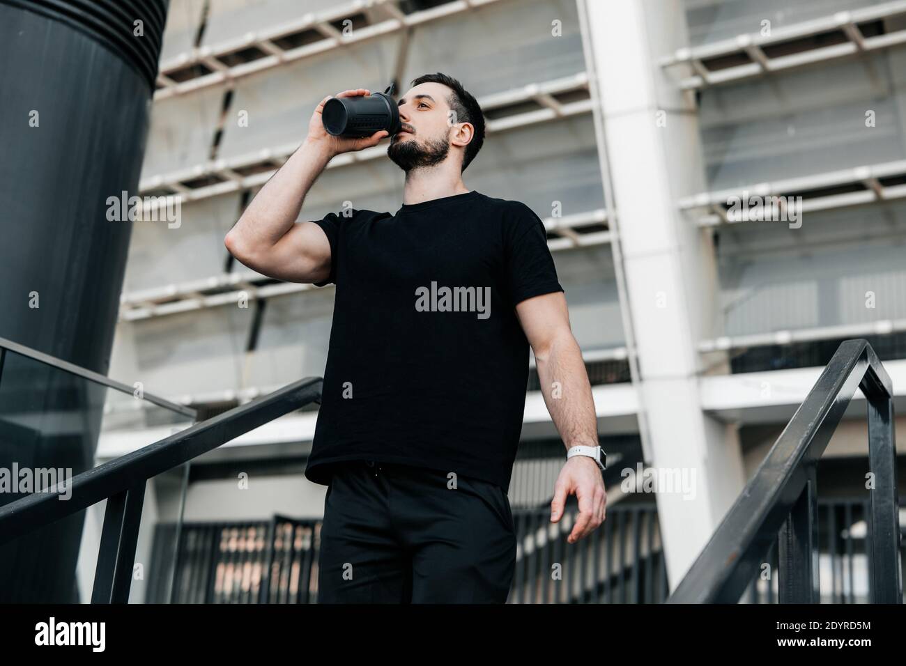 Tempo di idratazione l'uomo beve acqua dalla bottiglia sportiva dopo il jogging. Allenamento duro. Prenditi cura del concetto di yoself. Bere più acqua. Non ti dimenticare Foto Stock