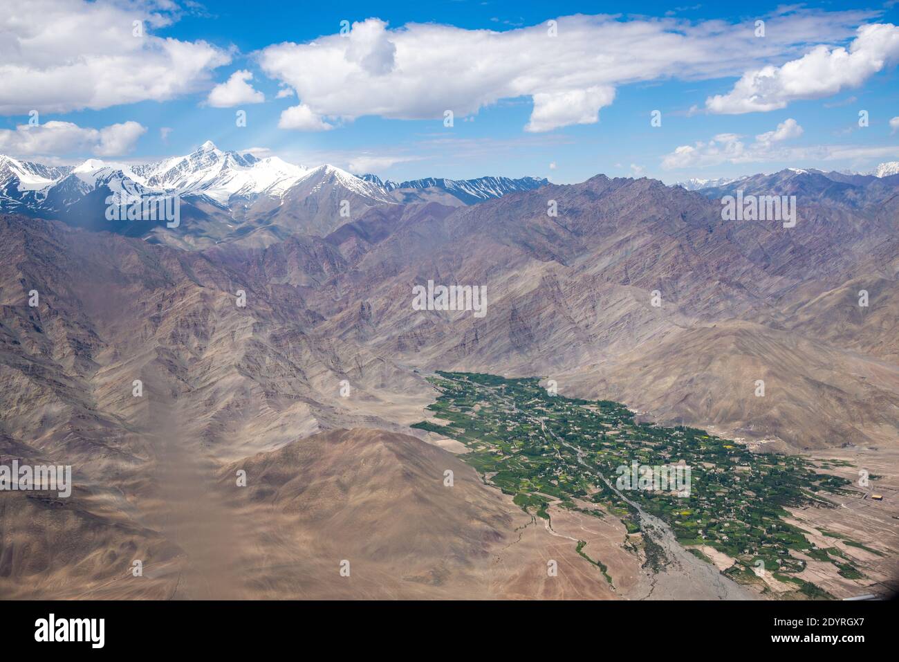 Vista sulla catena montuosa con villaggio nella valle verde a Ladakh, India Foto Stock