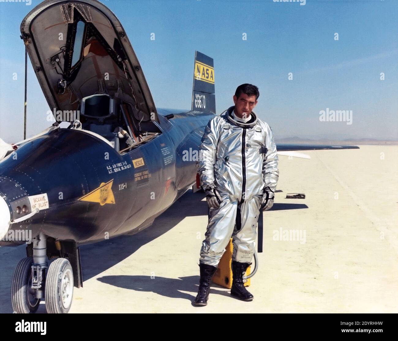 Michael J. Adams con X-15 marzo 22, il pilota di prova dell'aeronautica Major Michael J. Adams si trova accanto alla nave numero uno di X-15. Adams è stato selezionato per il programma X-15 nel 1966 e ha fatto il suo primo volo il 6 ottobre 1966. Il 15 novembre 1967, Adams fece il suo settimo e ultimo volo X-15. L'X-15 è stato lanciato dal B-52, ma durante la salita un problema elettrico ha influenzato il sistema di controllo dell'X-15. L'aereo si schiantò a nord-ovest del lago Cuddeback, California, causando la morte di Adams. Gli è stato assegnato postumo le ali dell'astronauta dell'aeronautica perché il suo volo finale supera Foto Stock