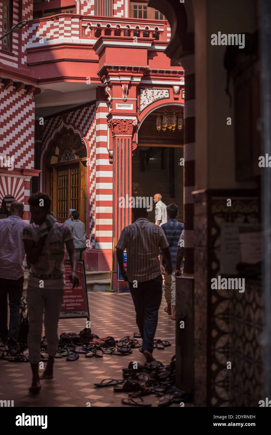 COLOMBO, SRI LANKA - 03-04-2019 : la facciata decorativa rossa e bianca della Moschea Jamiul Alfar, Moschea Rossa, nei quartieri più antichi di Colombo, gente s Foto Stock