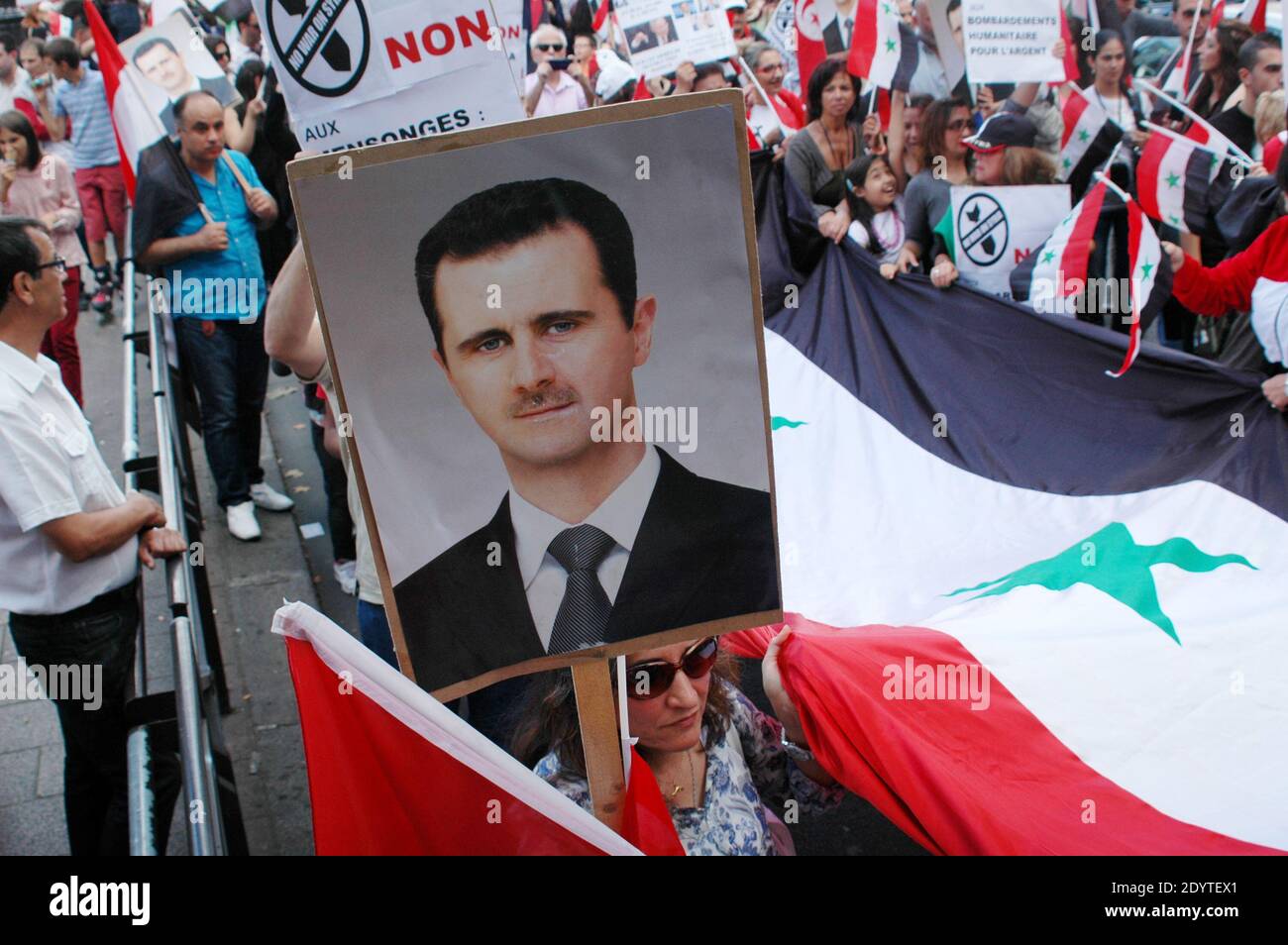 I manifestanti sollevano ritratti del presidente siriano Bashar al-Assad a Parigi, in Francia, l’8 settembre 2013, per protestare contro un potenziale attacco militare contro la Siria. Il presidente siriano Bashar al-Assad ha negato in un’intervista alla televisione della CBS che era dietro un attacco chimico il mese scorso e ha invitato i legislatori a rifiutare attacchi militari americani pianificati, ha dichiarato la rete americana l’8 settembre. Foto di Alain Apaydin/ABACAPRESS.COM Foto Stock