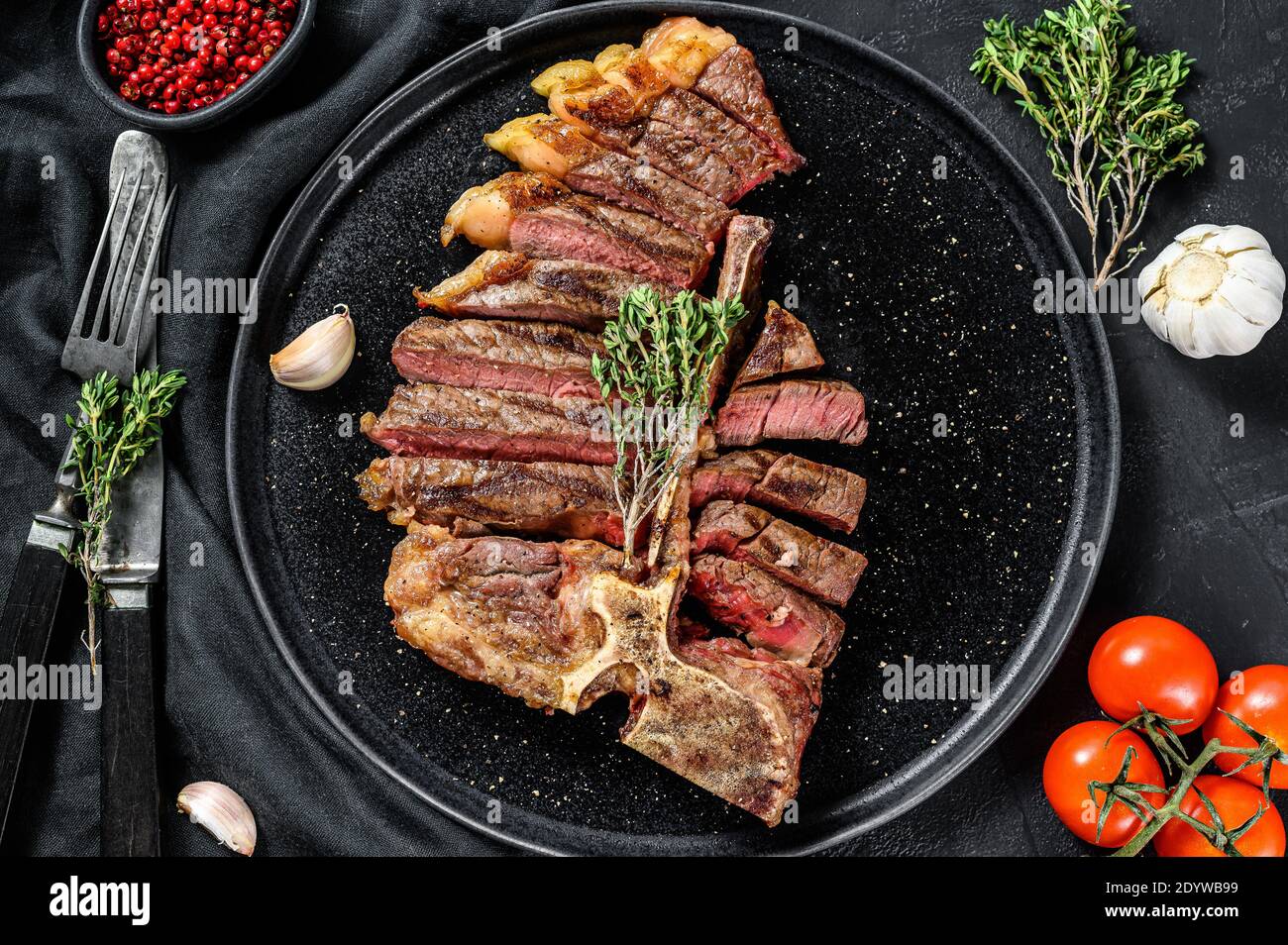 Bistecca fiorentina alla griglia a fette. T carne bovina ossea. Sfondo  nero. Vista dall'alto Foto stock - Alamy