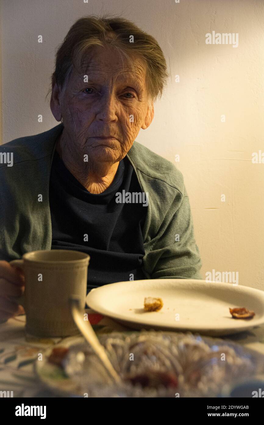 Una donna di 84 anni che soffre di depressione, con una tazza di caffè. Foto Stock