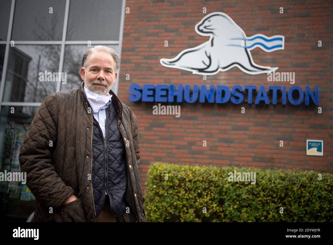 Norden, Germania. 23 dicembre 2020. Peter Lienau, capo della stazione delle foche, si trova di fronte all'ingresso del visitatore. Anche le foche del Mare del Nord hanno probabilmente risentito delle conseguenze della pandemia di Corona: Quando molti turisti si sono abbattuti sulla costa in estate, madri e giovani animali sono stati sempre più disturbati. Credit: Sina Schuldt/dpa/Alamy Live News Foto Stock