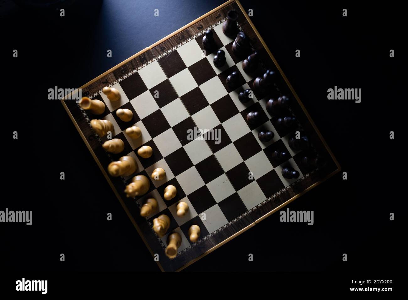 Vista alta dei pezzi di scacchi su una scacchiera in uno stile scuro. Foto Stock