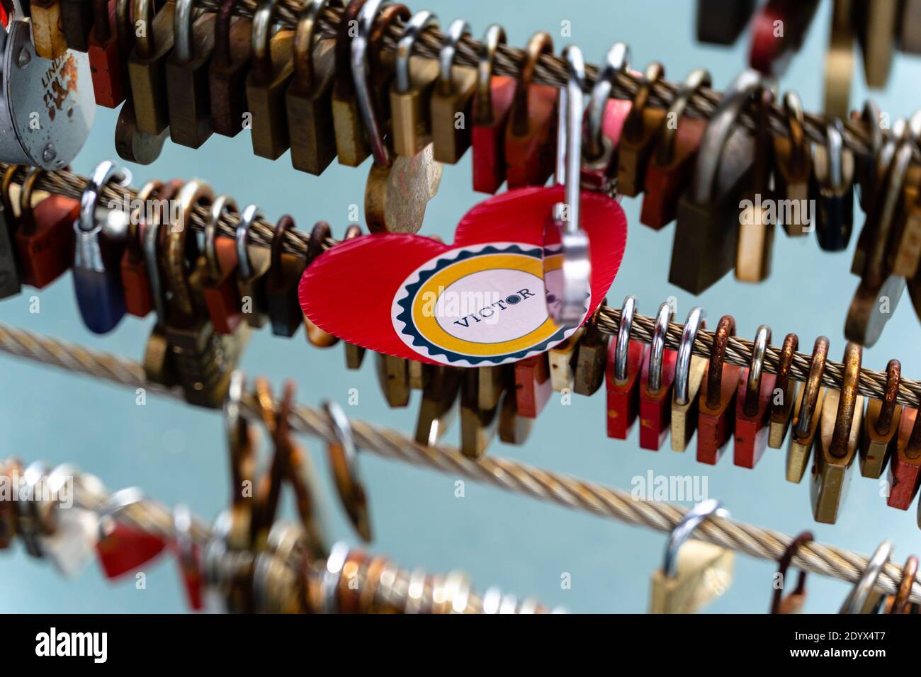 Scatto selettivo di serrature metalliche lasciate dalla gente su un ponte a Lubiana, Slovenia - mantenere un sogno Foto Stock