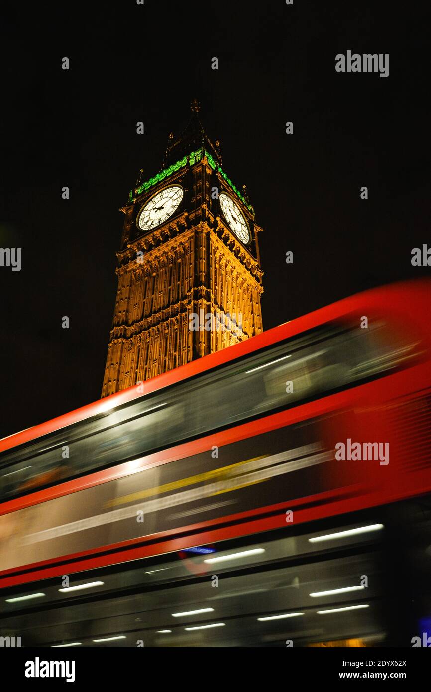 scia di autobus rosso che passa dal Big ben e il Parlamento britannico di notte. Londra, Regno Unito Foto Stock