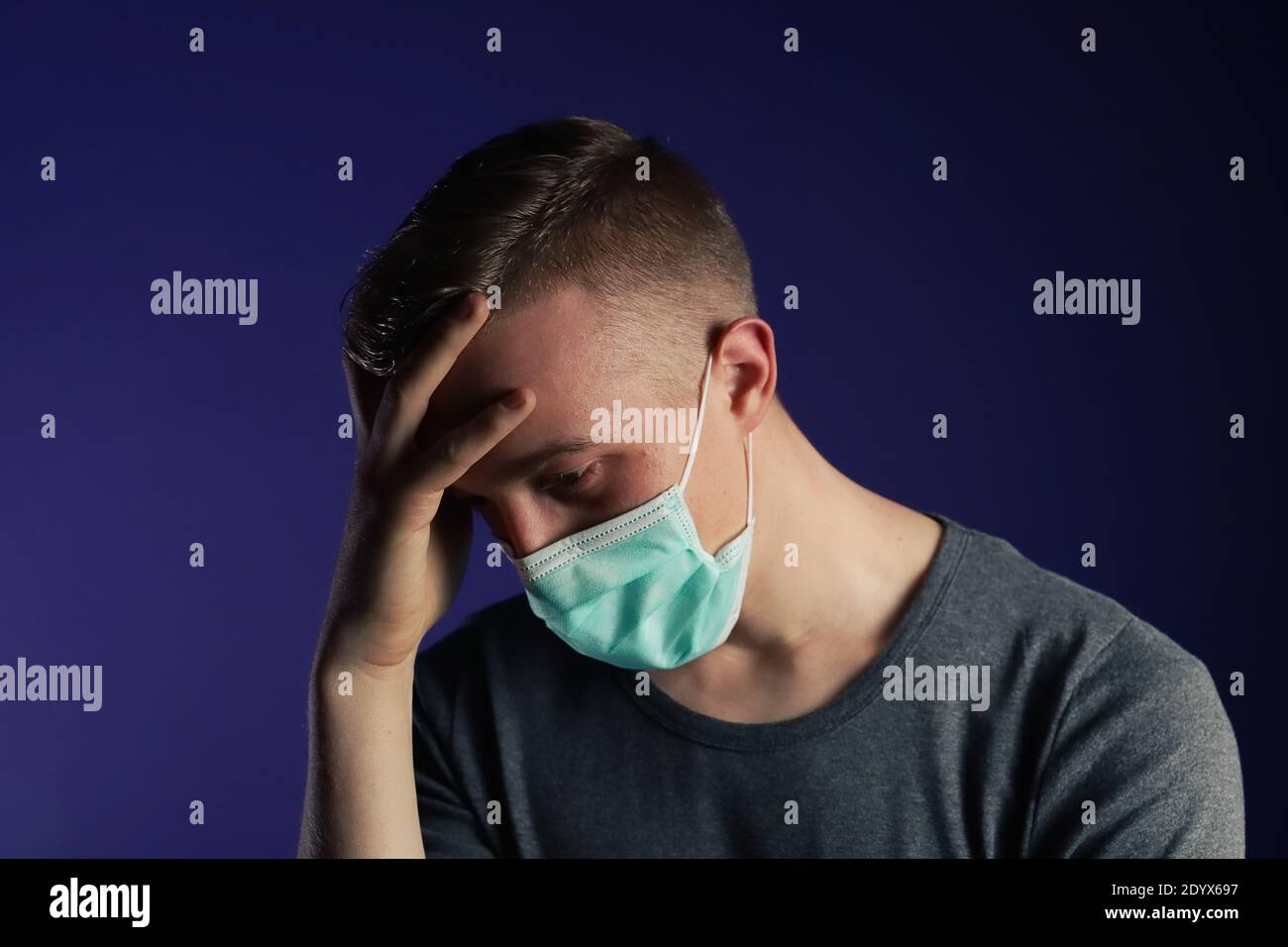 Uomo caucasico in maschera medica gause con palmo sulla testa NIS. Foto Stock