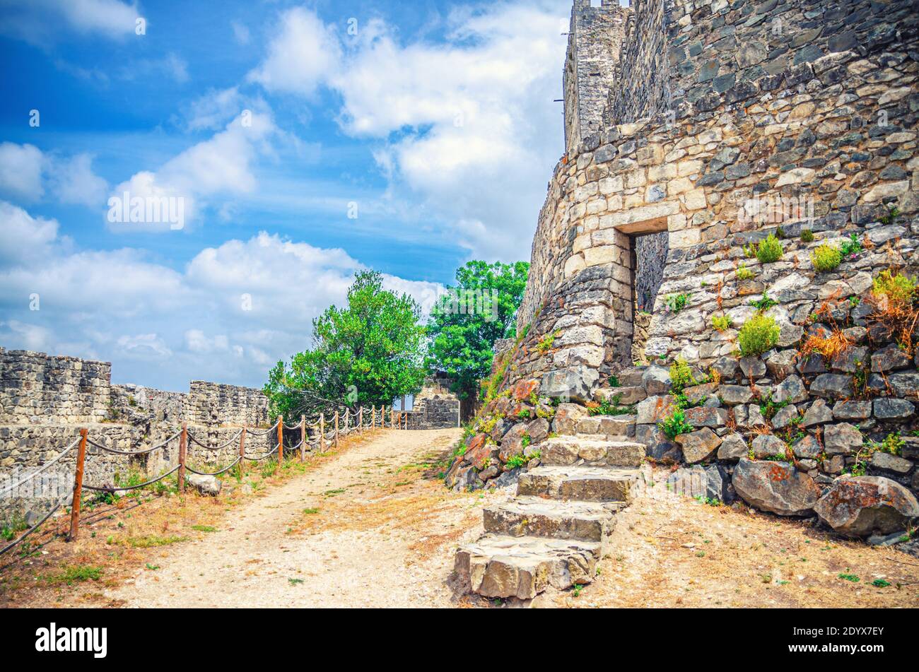 Cortile del castello medievale di Leiria Castelo de Leiria con pareti in pietra e scale circostanti, alberi verdi e sentiero con recinzione, Portogallo Foto Stock
